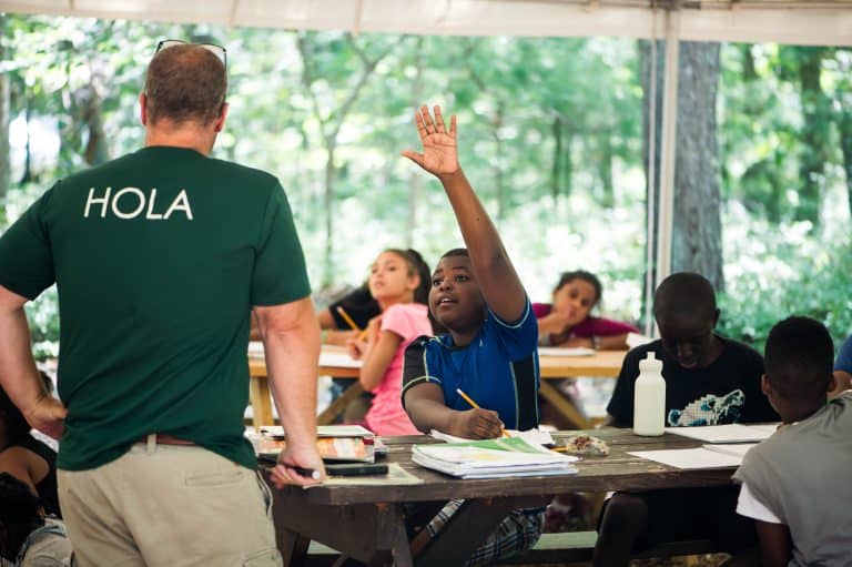 Kid raising hand in class.
