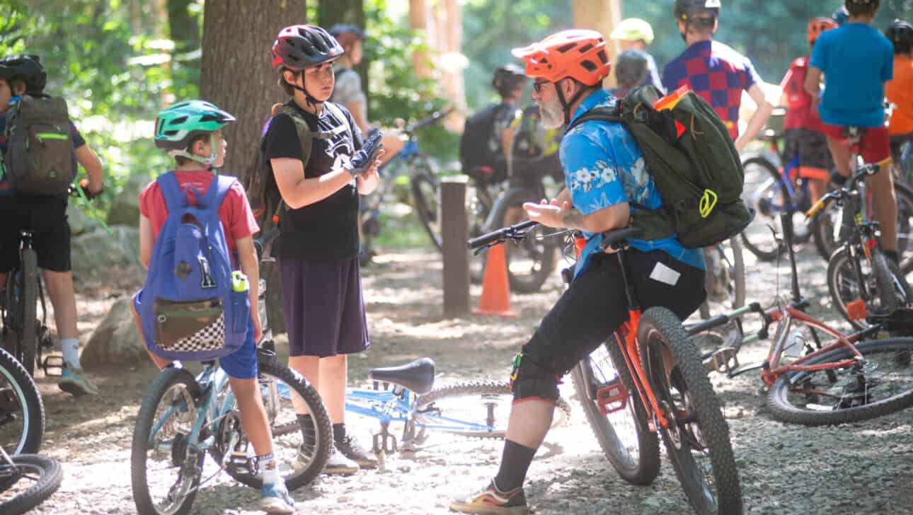 A group of mountain bikers in a wooded area.