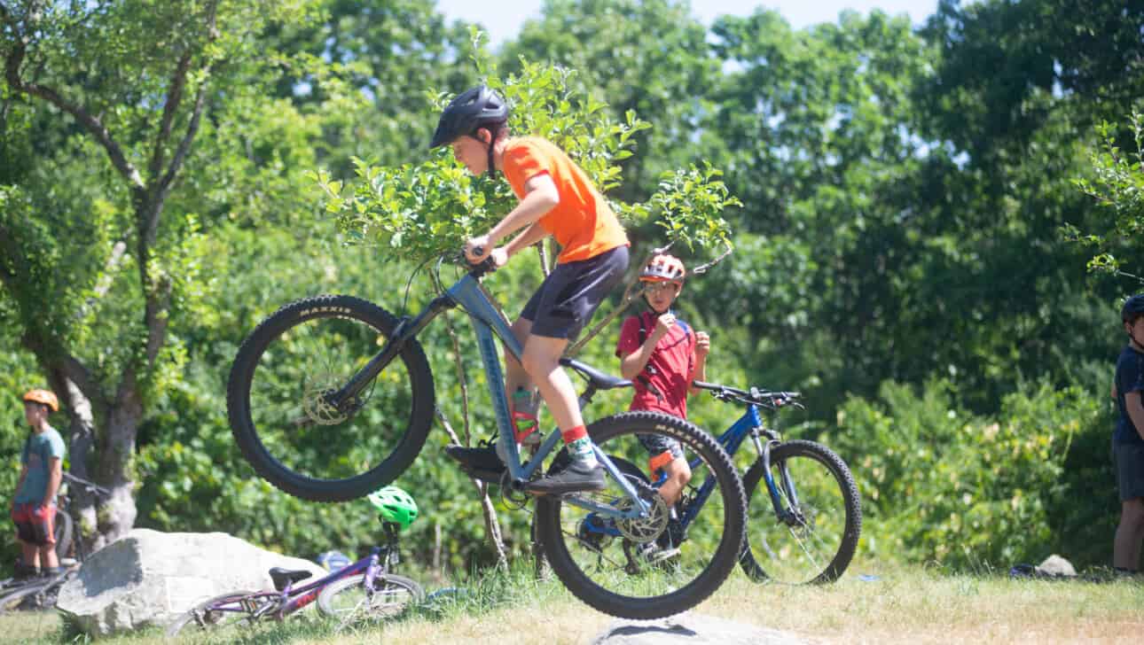 A boy is riding a mountain bike on a rock.
