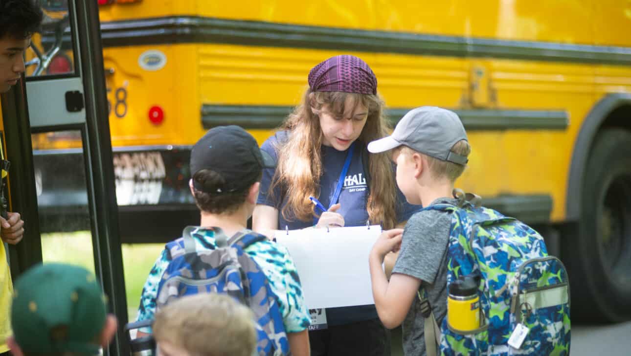 A group of children standing in front of a school bus.
