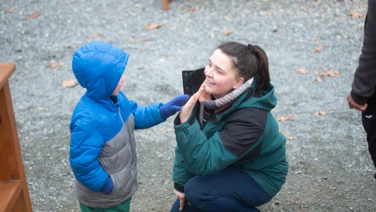 A woman giving a child a high five.